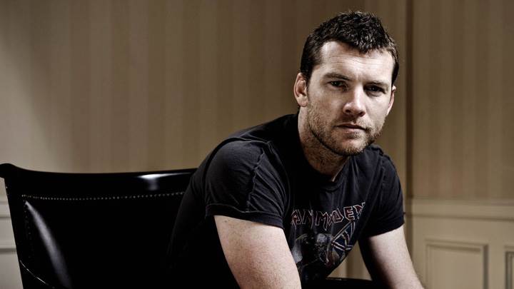 Sam Worthington In Black T-Shirt Sitting On Chair